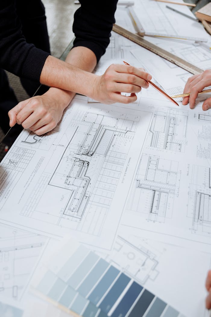 Architects discussing detailed blueprints and schematics at a table.